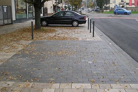 Parkplatz für mobilitätseingeschränkte Menschen, dahinter ein verbotswidrig abgestellter Pkw