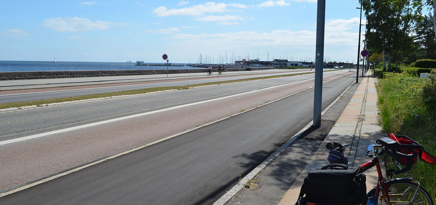 Uferpromenade nördlich von Kopenhagen. Hier ist Platz für alle: Vom Rand zur Mitte gibt es gleichberechtigt Fußweg, Radweg, einen Trennstreifen, Kfz-Fahrbahn und einen schmalen Grünstreifen.